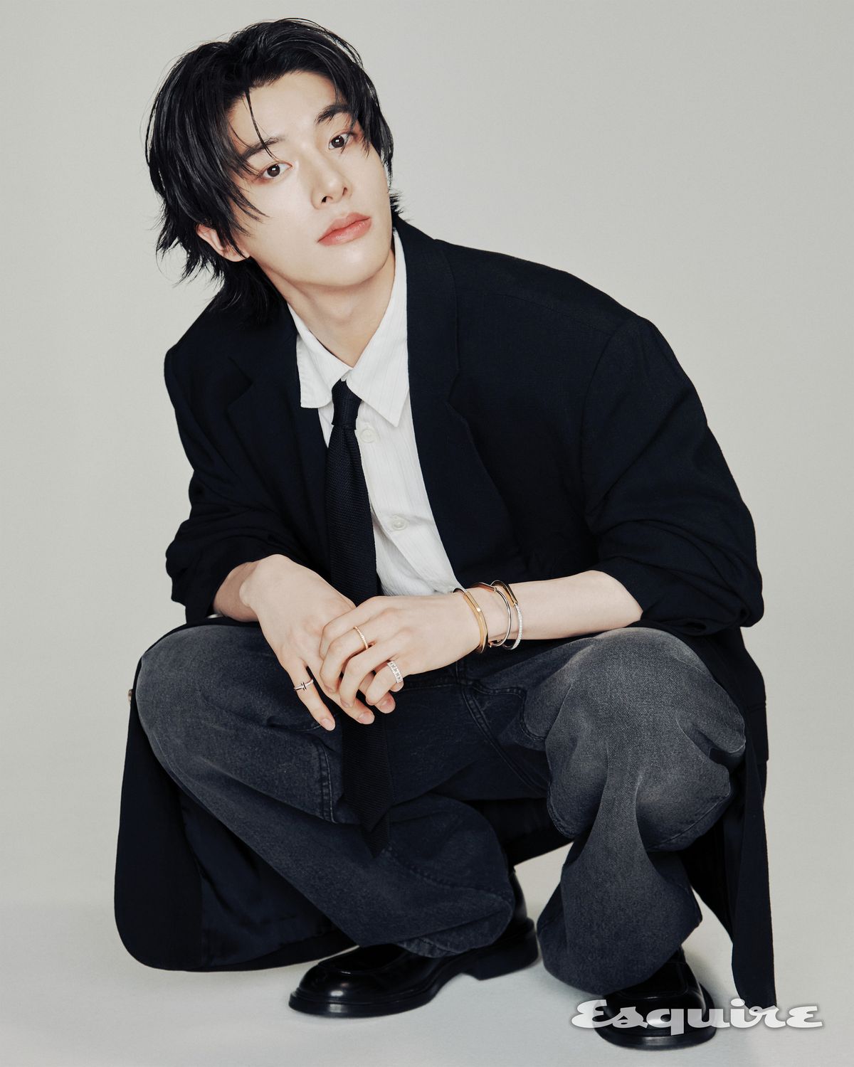 오른손 소지에 착용한 화이트 골드 소재의 티파니 T 링, 왼손 중지에 착용한 옐로 골드 소재의 티파니 락 하프 파베 링, 소지에 착용한 화이트 골드 소재의 티파니 T 트루 와이드 링, 손목에 착용한 옐로 골드 소재의 티파니 락 하프 파베 뱅글, 로즈 골드 소재의 티파니 락 내로우 하프 파베 뱅글, 로즈 골드 소재의 티파니 락 하프 파베 뱅글 모두 티파니. 재킷 렉토. 셔트, 타이, 슈즈 모두 아워레가시. 팬츠 스타일리스트 소장품.