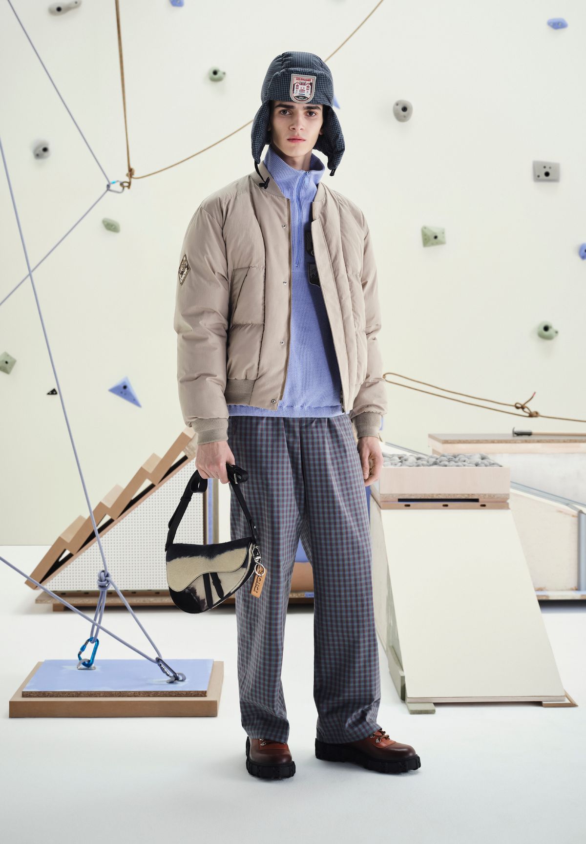 테크니컬 코튼 푸퍼 블루종, 하프 지퍼 스웨트셔츠, 포플린 조거 팬츠, 이어 플랩, 디올 슬릭락 부츠, 디올 히트 더 로드 메신저백, 키링 모두 디올 맨.