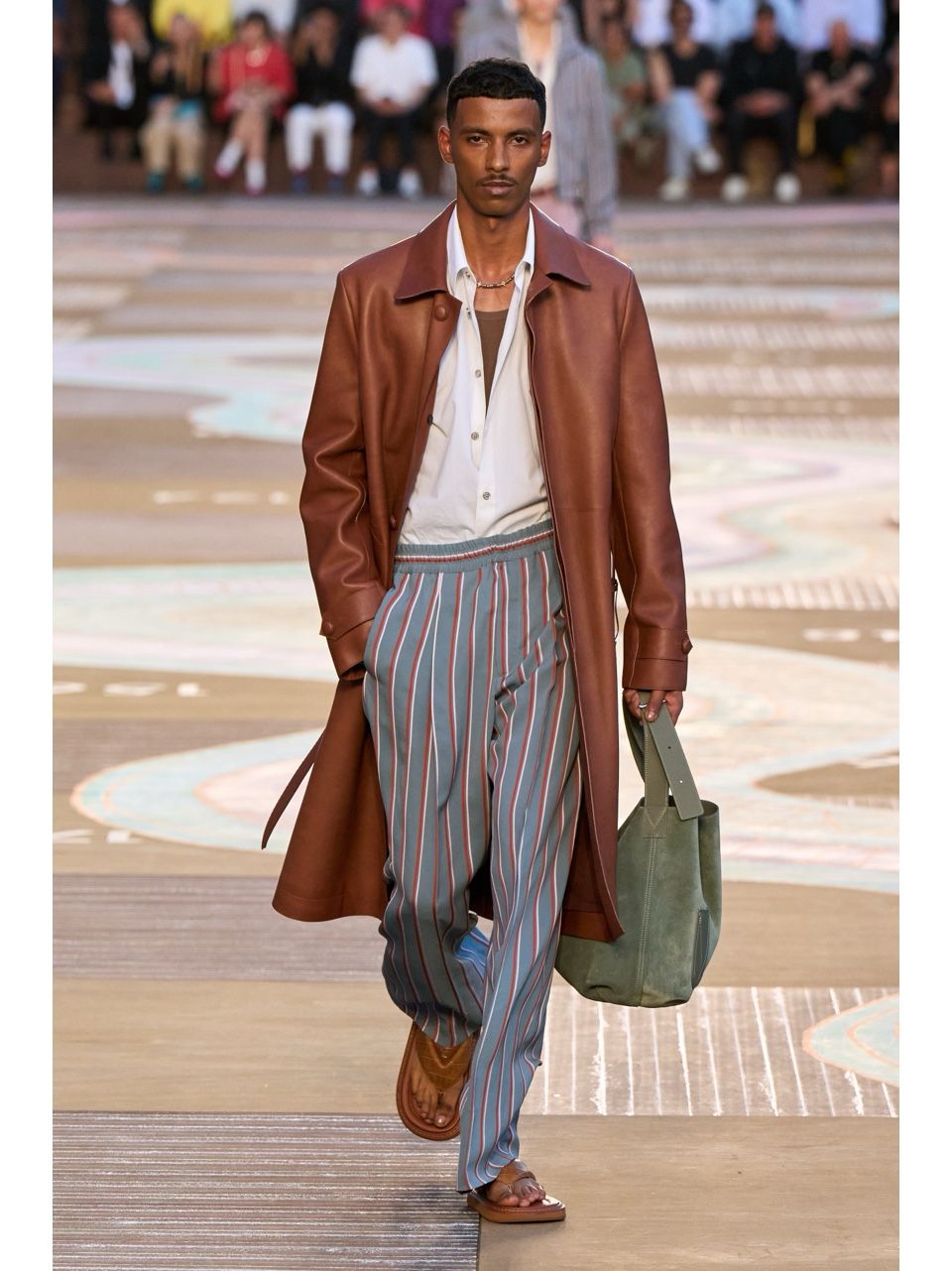 브라운 코트와 스트라이프 팬츠, 살짝 단추를 푼 셔츠의 스타일링이 돋보이는 런웨이 모습. / 이미지 출처: 루이 비통.