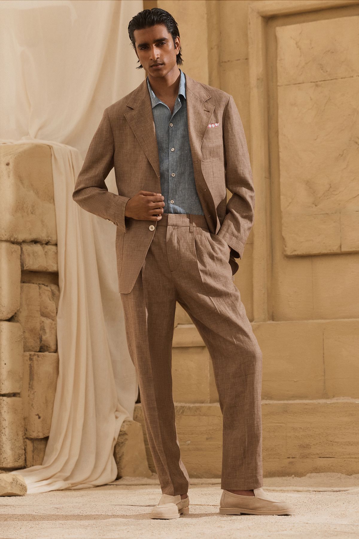 리넨 특유의 슬러브와 짜임이 고급스럽게 살아있는 브라운 컬러의 싱글 브레스트 수트 재킷과 투-플리츠 와이드 슬랙스 셋업 / 이미지 출처: 브루넬로 쿠치넬리