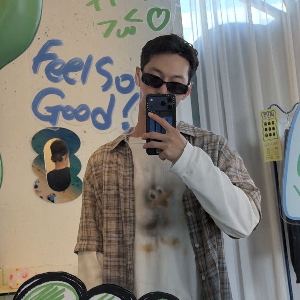 그래픽 흰 긴팔 티셔츠 위에 반팔 체크 셔츠를 걸친 도영의 가을 레이어드. / 이미지 출처: @do0_nct