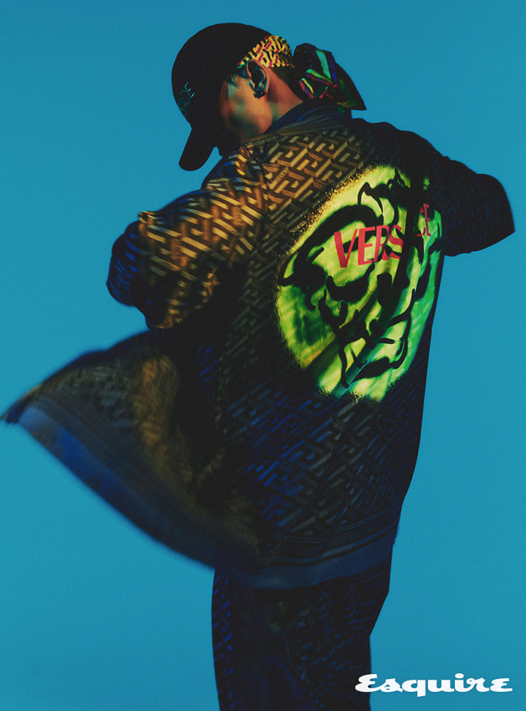 그래픽 메두사 프린트 재킷, 블랙 그래픽 프린트 팬츠, 블랙 로고 볼캡, 그래픽 프린트 스카프 모두 베르사체.