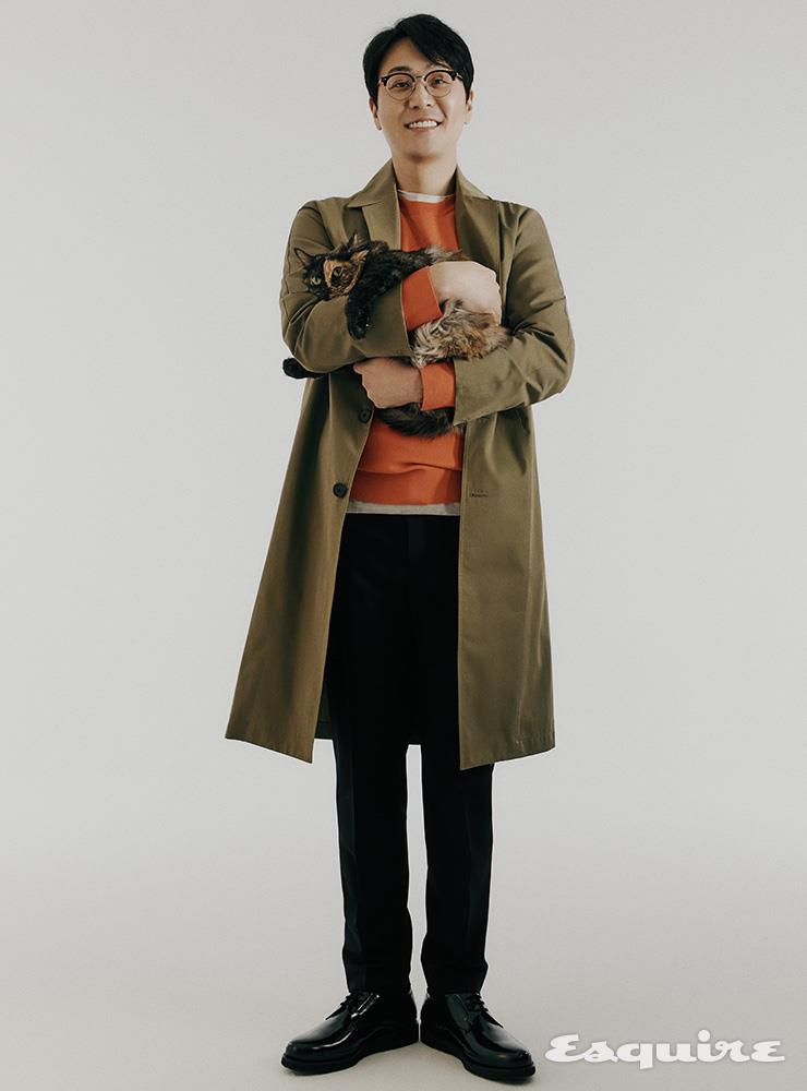 트렌치코트, 오렌지 스웨터, 화이트 티셔츠, 울 슬랙스, 네오프렌 콤비 더비 슈즈 모두 타임옴므.