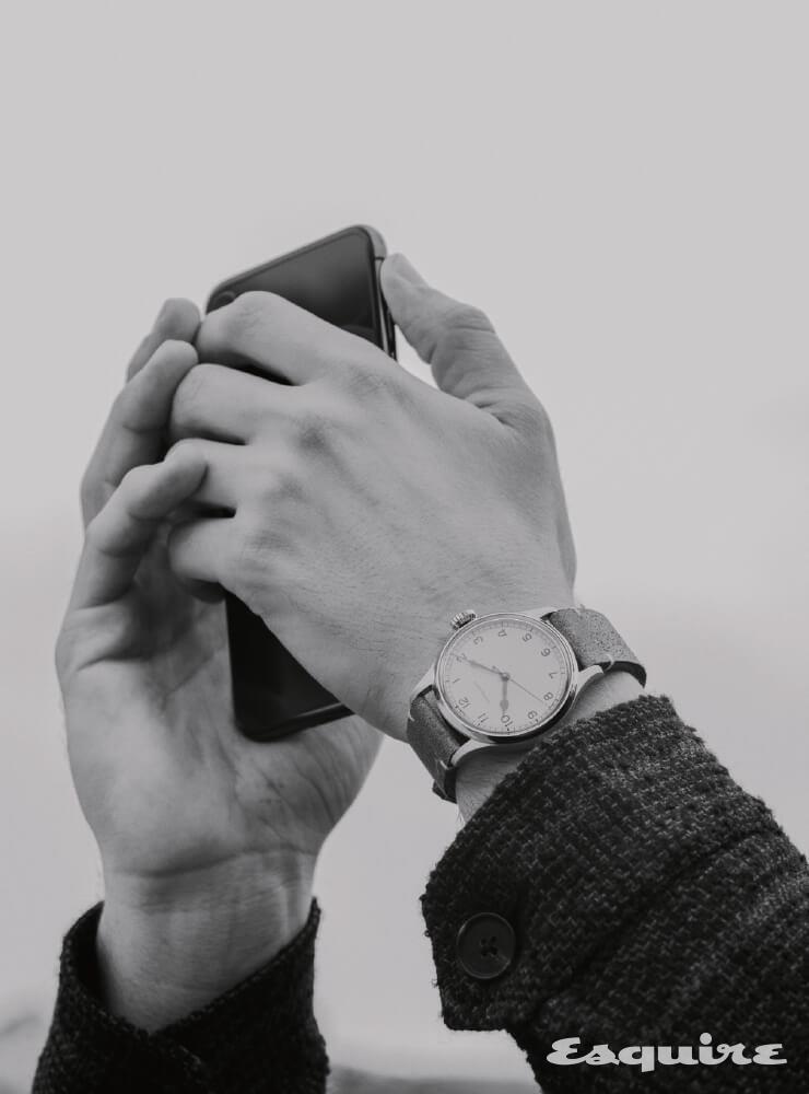 LONGINES 헤리티지 밀리터리, 38.5mm 폴리시드 스틸, 카키색 가죽 스트랩, 275만원. 남색 울 해링턴 재킷 해켓.