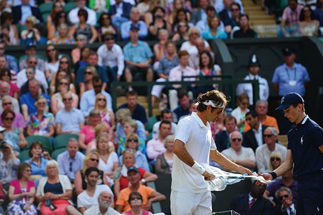 2014년 윔블던, 노박 조코비치에게 패했던 남자 단식 결승에서의 페더러. 볼 보이의 도움으로 새 라켓의 비닐을 벗기는 모습.