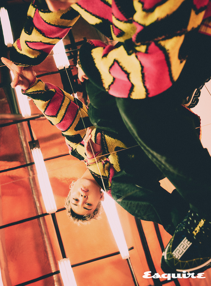 옐로 그래픽 프린트 니트 톱, 블랙 그래픽 프린트 팬츠, 블랙스니커즈, 네크리스 모두 베르사체.