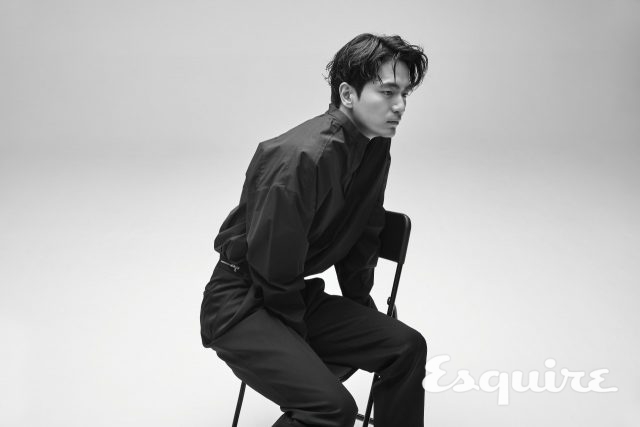 블랙 브이넥 셔츠, 블랙 바지 모두 준지. 블랙 레터링 스니커즈 컨버스.