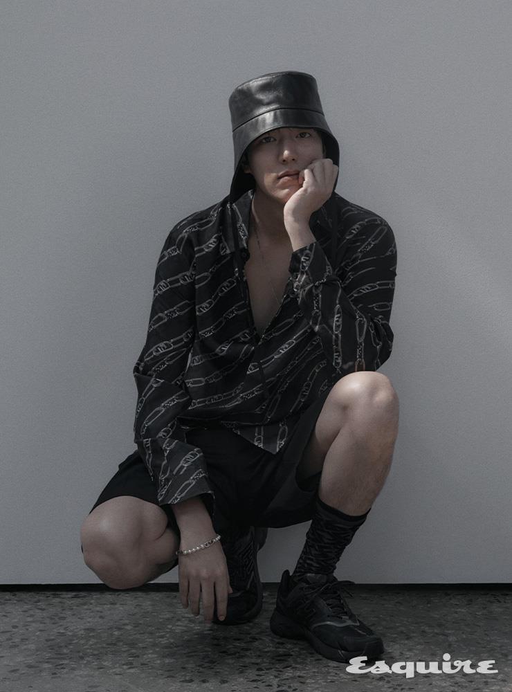 펜디 오’락 체인 모티브 프린트의 실크 셔츠, 울 버뮤다 팬츠, 펜디 패스터 스니커즈, FF 모티브 삭스, 이어 플랩과 스트링이 달린 레더 해트, 메탈 펜디 오’락 모노그램 장식의 펄 소재 브레이슬릿 모두 펜디.