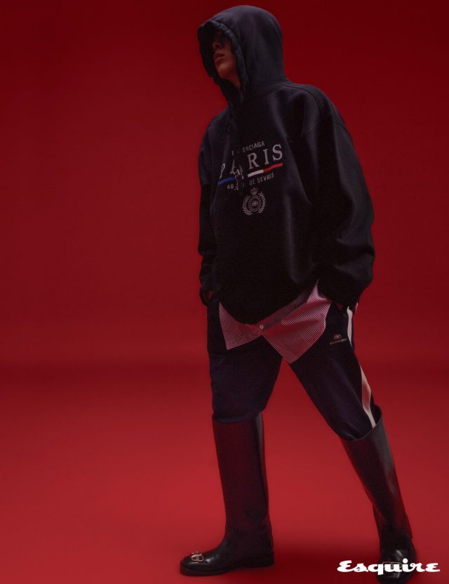 오버사이즈 후디, 롱 스트라이프 셔츠, 트랙 슈트 팬츠, BB 로고 장식의 레인 부츠, 후디 스트링에 달린 에펠탑 모양 귀걸이 모두 발렌시아가.