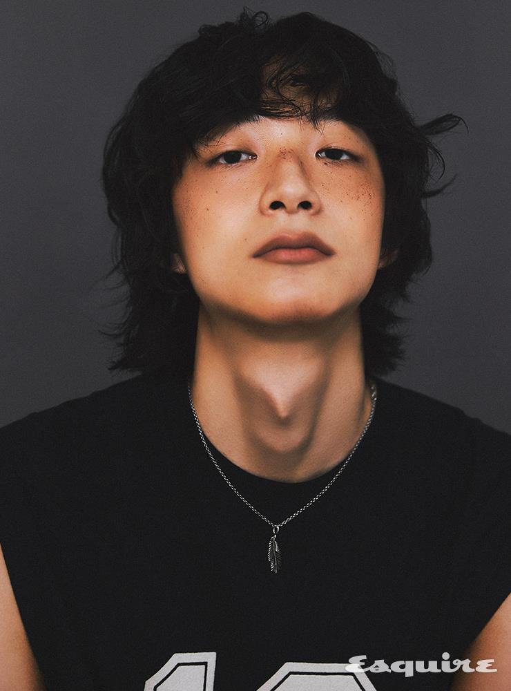 블랙 슬리브리스 톱 가격 미정 셀린느 옴므 by 에디 슬리먼. 깃털 펜던트 네크리스 가격 미정 생 로랑 by 안토니 바카렐로.