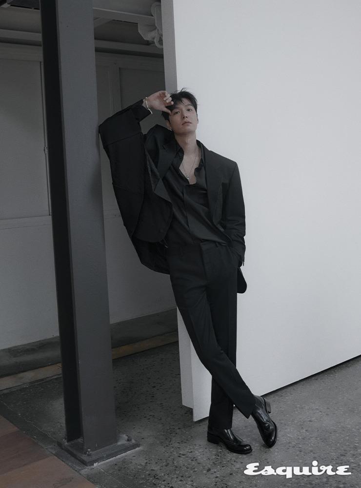 블레이저 형태의 플레어 케이프, 마이크로 FF 자카르 디테일의 실크 셔츠, 레귤러 핏 팬츠, 힐 부분에 메탈 펜디 오’락 디테일을 장식한 첼시 부츠, 크리스털 및 FF 모티브 장식의 네크리스 모두 펜디.