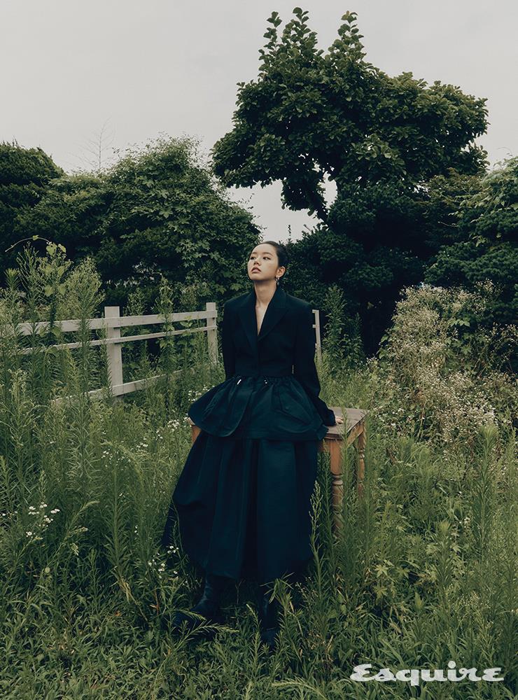 블랙 재킷, 블랙 스커트, 슈즈, 이어링 모두 알렉산더 맥퀸.