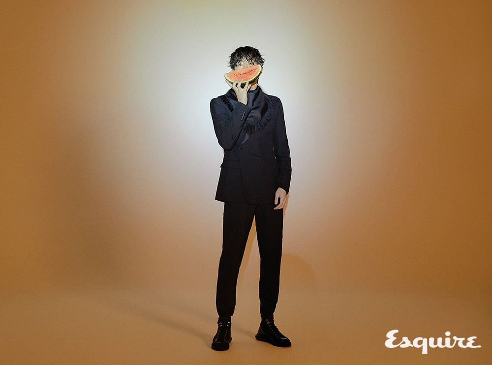 새틴 디테일의 검은색 울 모헤어 오블리크 슈트, 검은색 실크 트윌 프린지 반다나, 검은색 러버 솔 레이스업 부츠 모두 디올 맨.