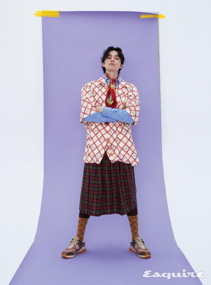 종이 같은 질감의 볼링 셔츠, 스트라이프 셔츠, 오버사이즈 타탄 쇼츠, GG 패턴 양말, 다양한 구찌 로고 디테일과 멀티컬러가 조화된 울트라페이스 스니커즈, 말과 안장 프린트의 실크 스카프 모두 구찌.