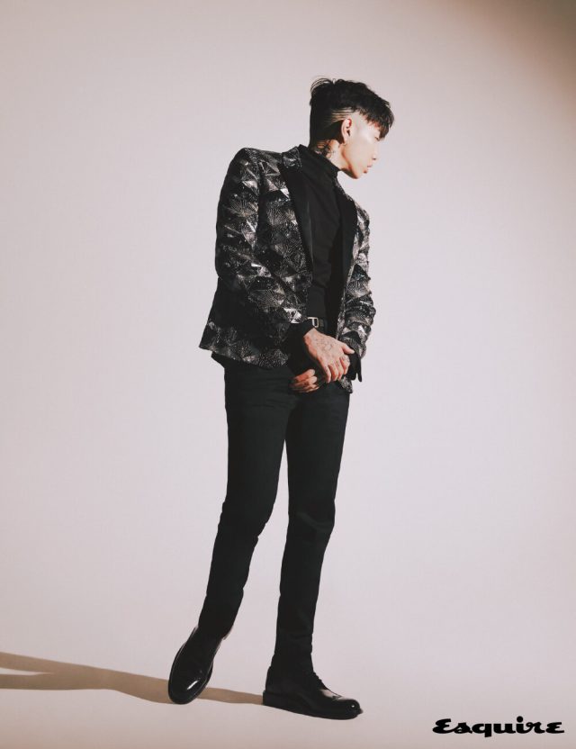 골드 아르 데코 패턴 엠브로이더리 쇼트 재킷, 터틀넥 톱, 스트레이트 데님 팬츠, 아미 더비 슈즈, 벨트 모두 생 로랑 by 안토니 바카렐로.