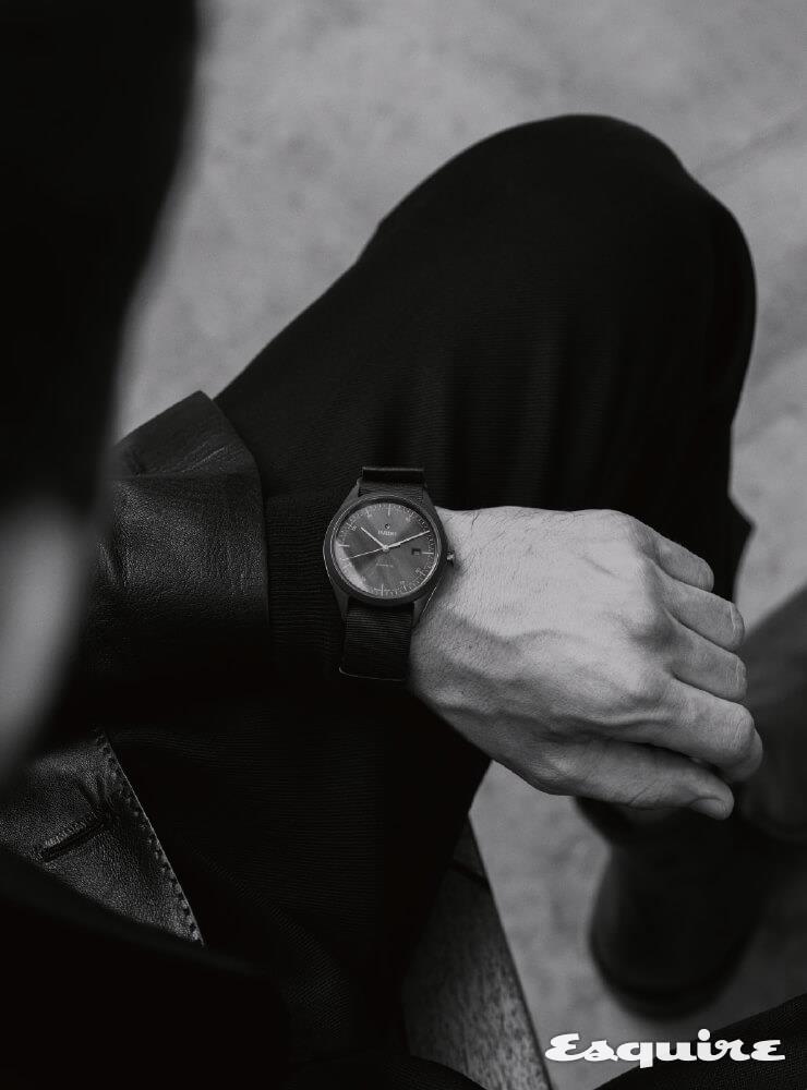RADO 하이퍼크롬 울트라 라이트, 43mm 하이-테크 세라믹, 갈색 나토 스트랩, 367만원. 검은색 가죽 재킷, 검은색 울 팬츠, 짙은 갈색 가죽 부츠 모두 벨루티.