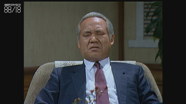 정한용(1954~) 배우. 해당 화면에서 정한용은 30대 정도였을 텐데도 장년층 연기를 하는 중이다. 영상 속 정한용은 정경유착이라는 개념에 대해 이야기하고 있다. 