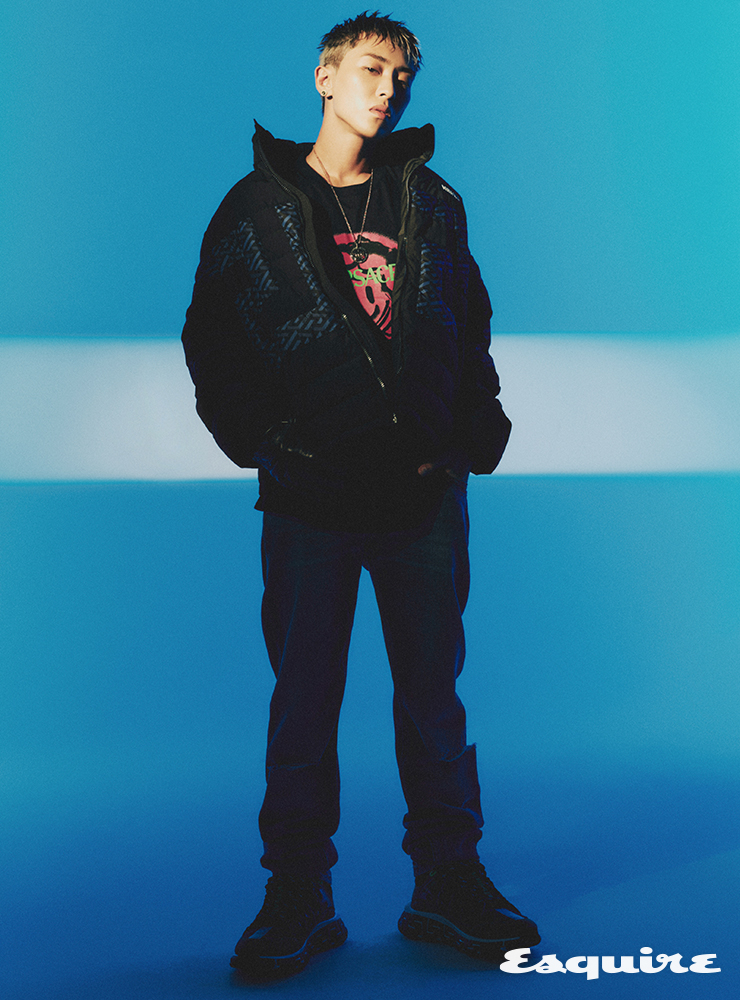 블랙 그래픽 포인트 패딩 재킷, 블랙 메두사 프린트 티셔츠, 블랙 그래픽 프린트 팬츠, 블랙 스니커즈, 블랙 레더 글로브, 네크리스 모두 베르사체.