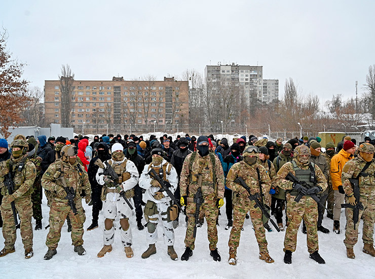러시아 침공 전날, 키이우 외곽의 버려진 공장에서 민간인들이 교관들과 함께 훈련하고 있다. 전 세계에서 온 봉사자들이 우크라이나 시민에 합류해 후방 지원에 큰 힘을 보탰다. &copy; SERGEI SUPINSKY/AFP/GETTY IMAGES