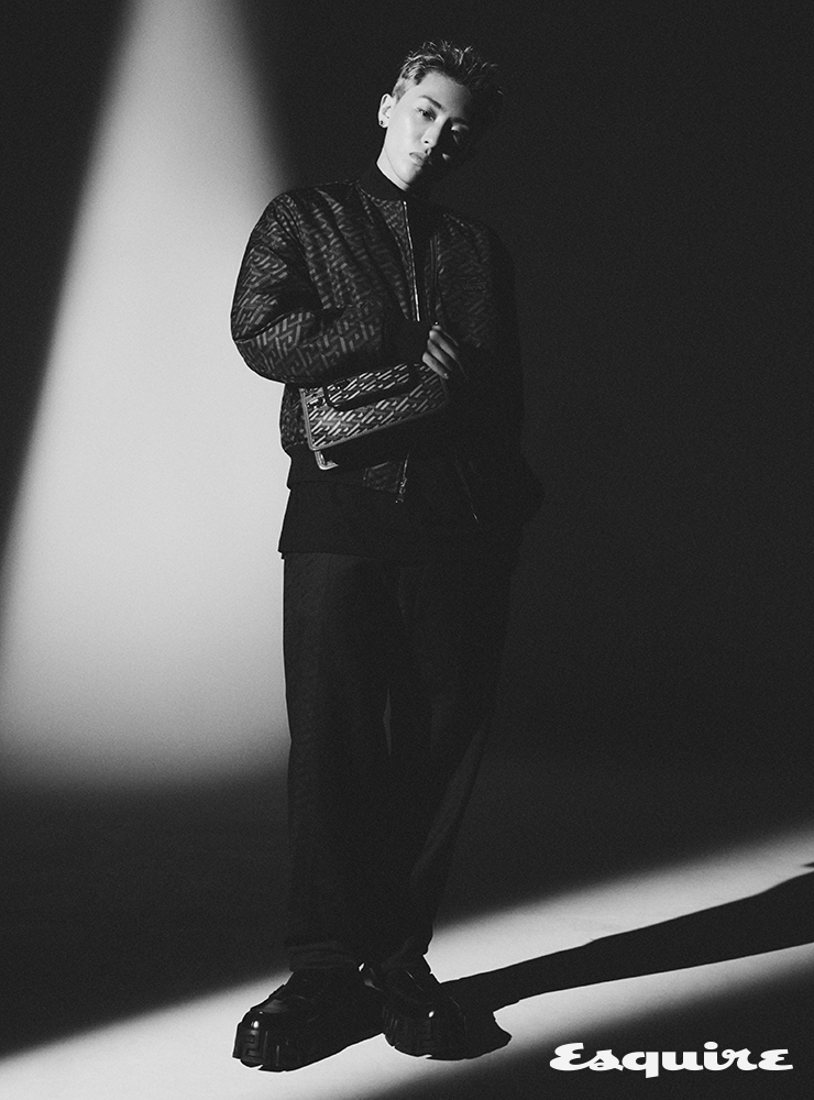 그래픽 프린트 블루종 재킷, 블랙 그래픽 프린트 팬츠, 블랙 레더 로퍼, 그래픽 프린트 크로스 백 모두 베르사체.