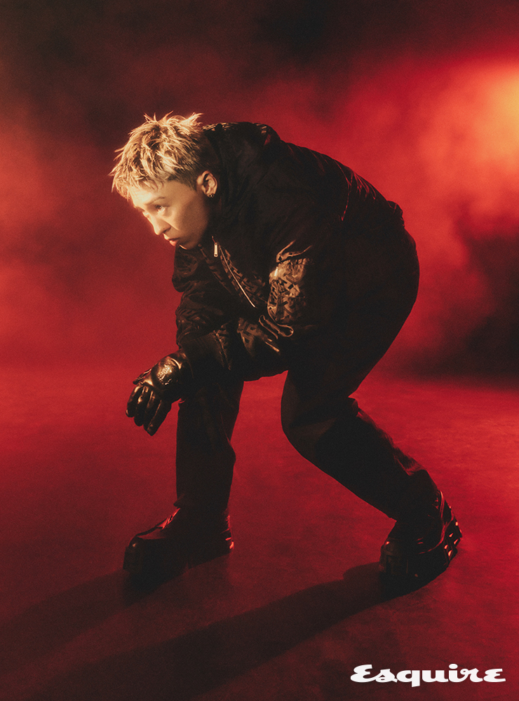 블랙 그래픽 프린트 후드 재킷, 블랙 팬츠, 블랙 레더 로퍼, 블랙 레더 글로브 모두 베르사체.