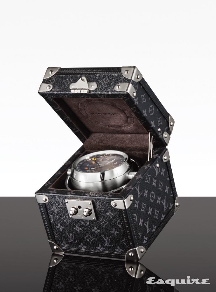 LOUIS VUITTON. 견고한 모노그램 이클립스 캔버스 트렁크 안에 8cm 사이즈의 시계를 담았다. 선명한 색감의 루이 비통 플래그로 다이얼을 장식했으며, 24시간 디스플레이와 GMT 인디케이터로 듀얼 타임을 보여준다. 트렁크 테이블 클락 745만원 루이 비통.