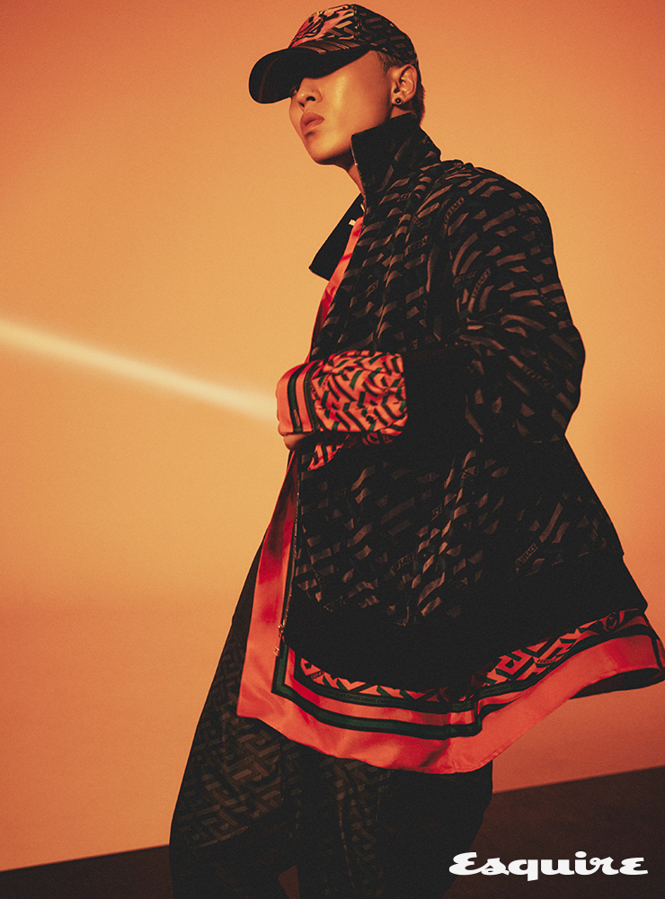 블랙 그래픽 프린트 블루종 재킷, 레드 그래픽 메두사 프린트 셔츠, 블랙 그래픽 프린트 팬츠, 메두사 프린트 볼캡 모두 베르사체.